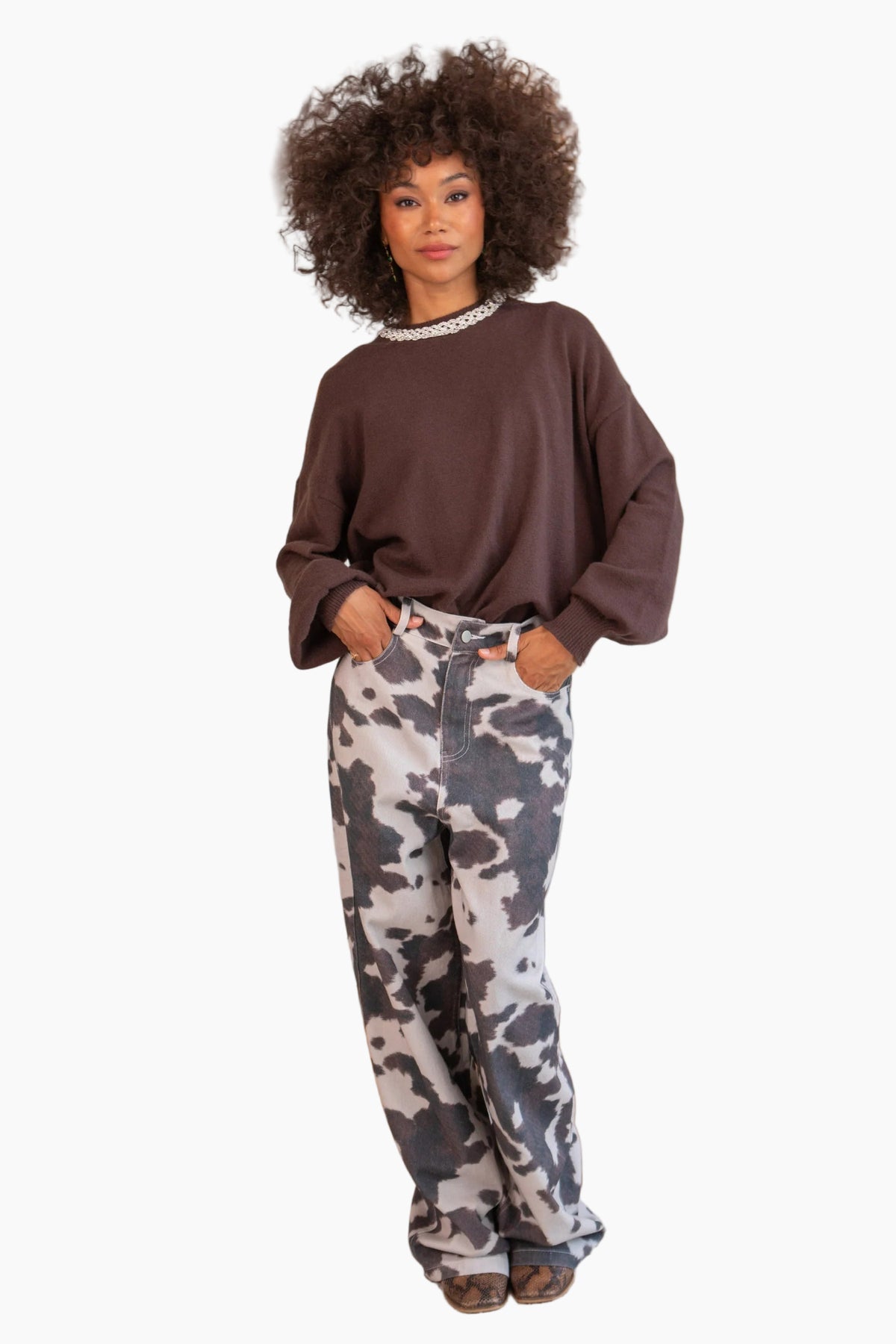 Woman wearing a brown sweatshirt and camouflage pants 
