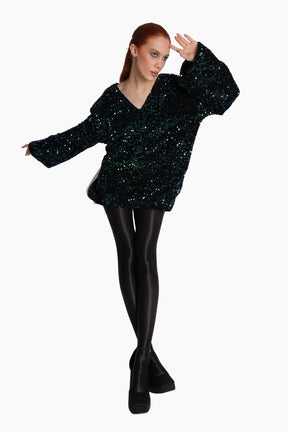 Person wearing a black sequin top and black tights 