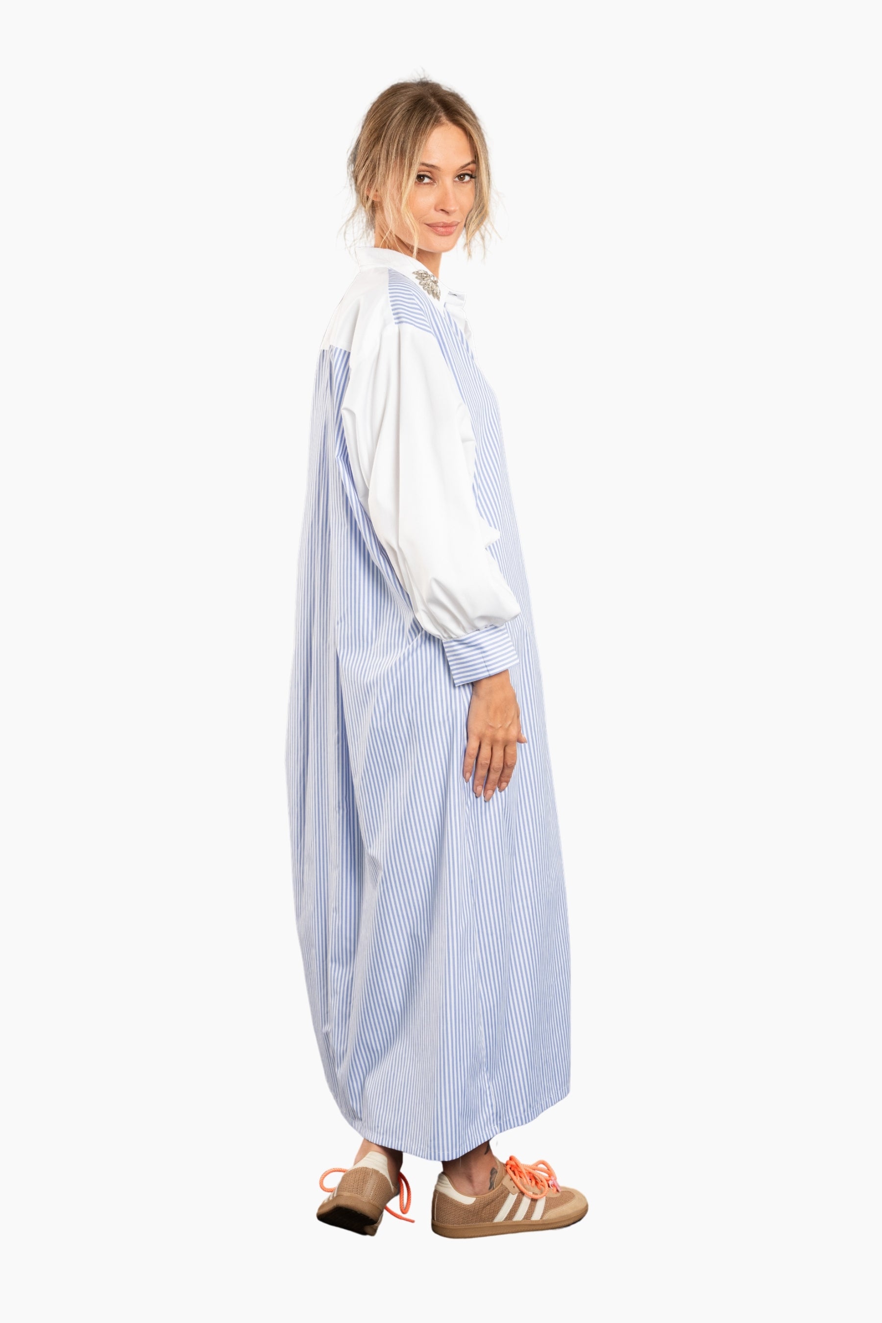 Woman wearing a light blue and white striped dress on a white background