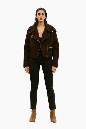 Woman wearing a brown jacket, black pants, and brown boots 