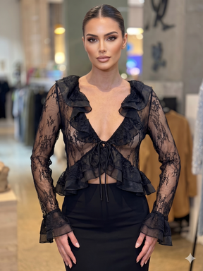 Woman wearing a black lace top in an indoor setting