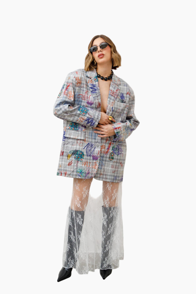 Person wearing a colorful patterned suit with sheer white pants 