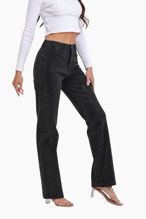 Person wearing black flared jeans and a white top 