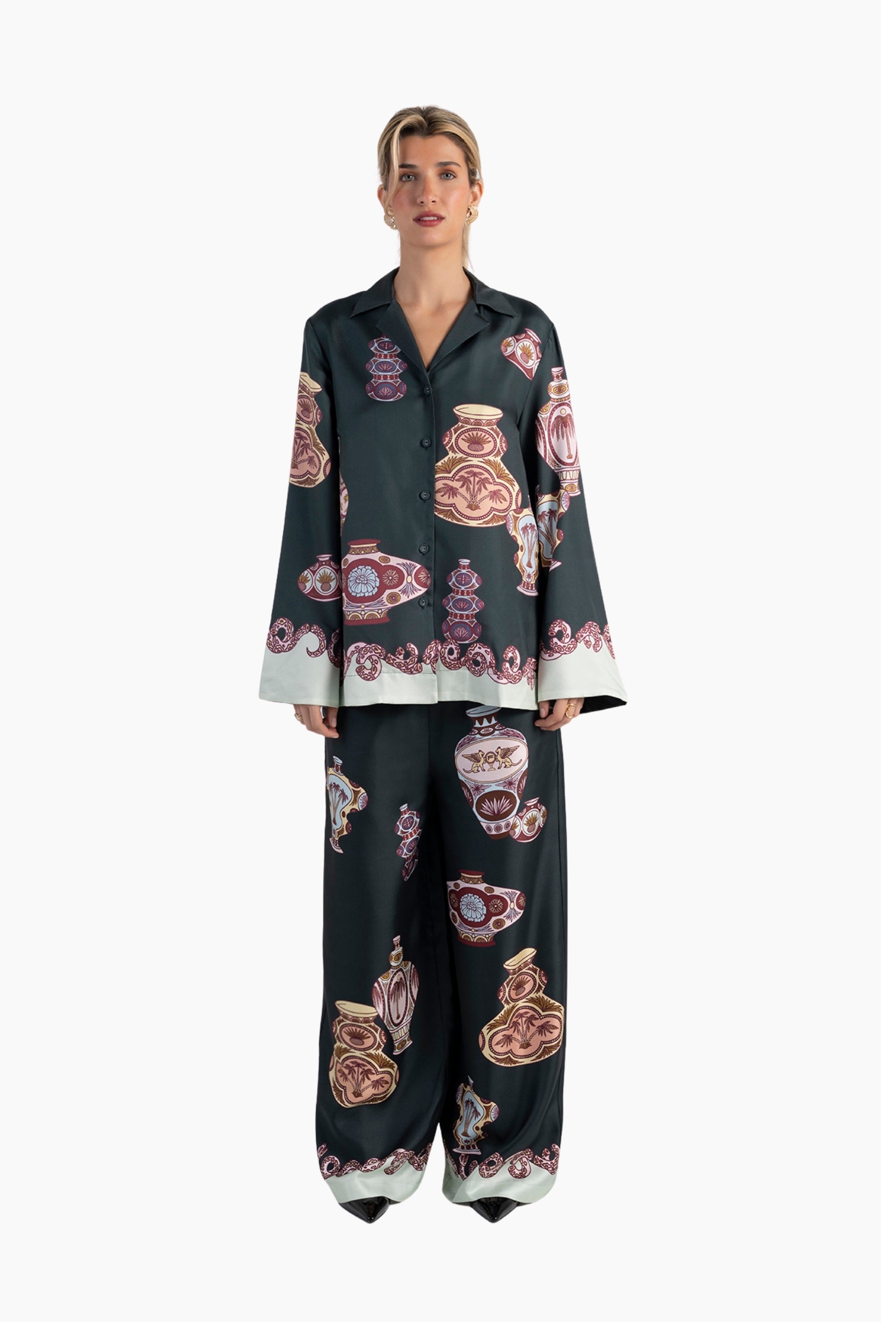 Woman wearing a black pajama set with a colorful abstract pattern on a white background