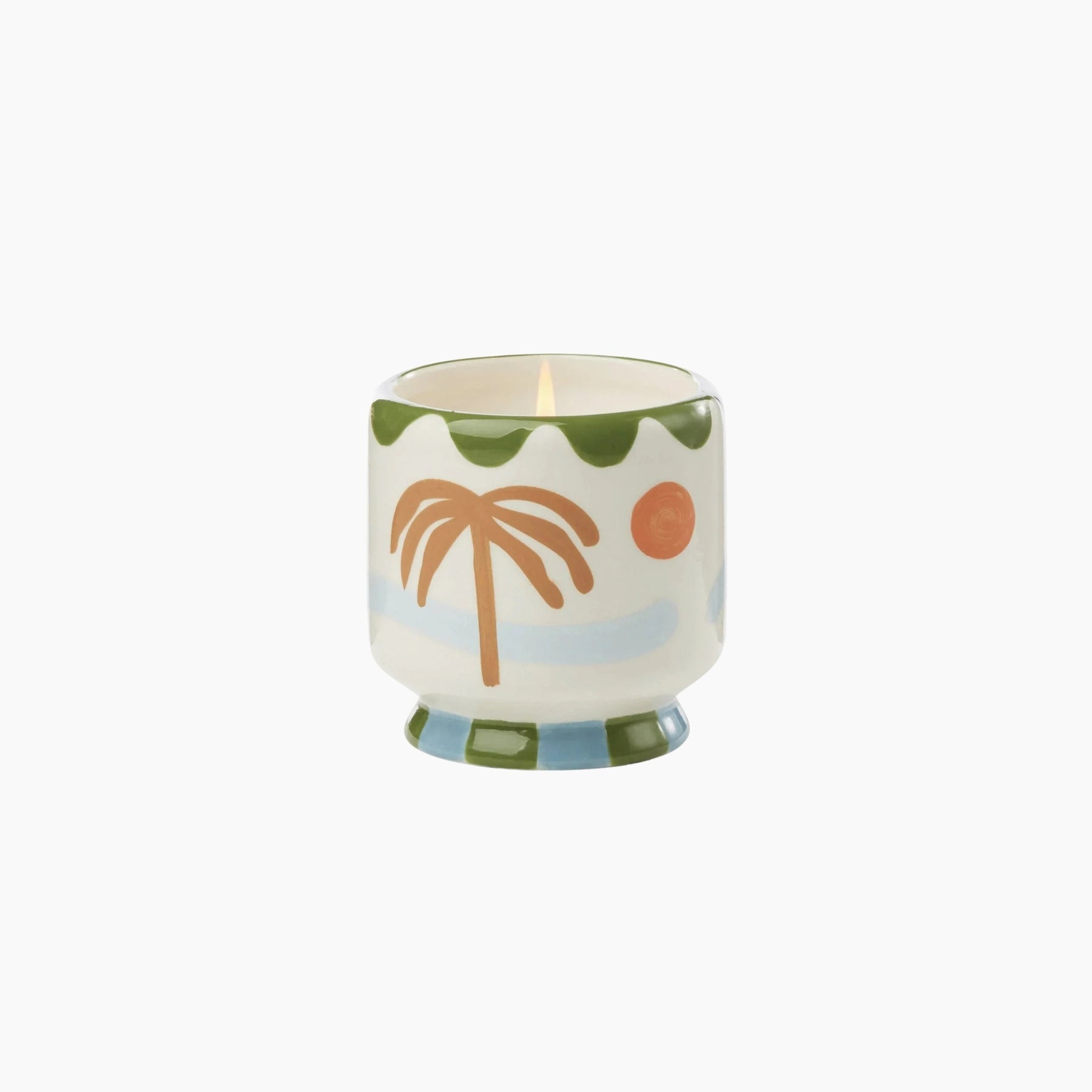 Decorative candle with palm tree design on a white background