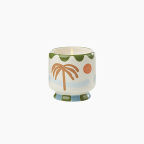 Decorative candle with palm tree design on a white background