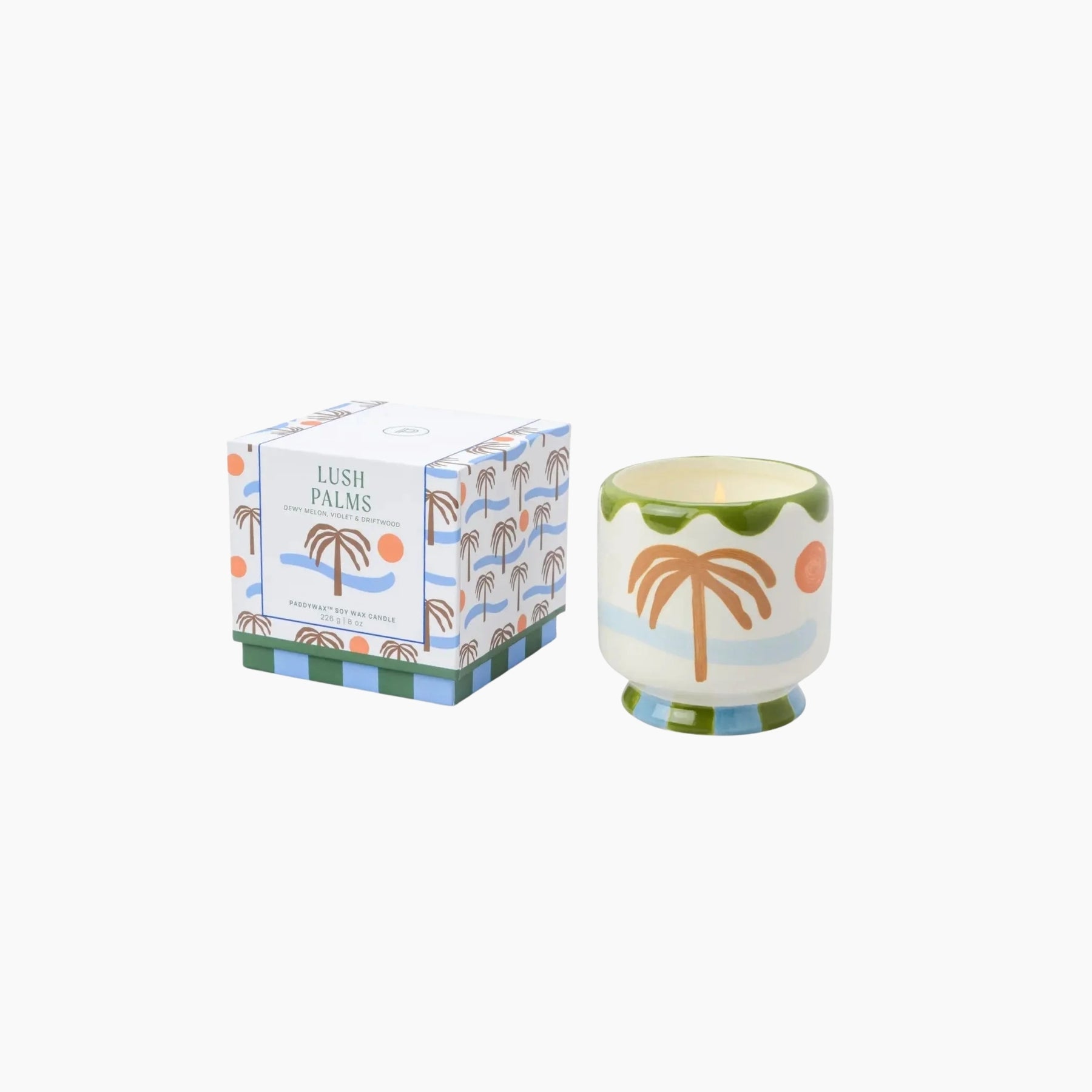 Candle with palm tree design and matching packaging on a white background
