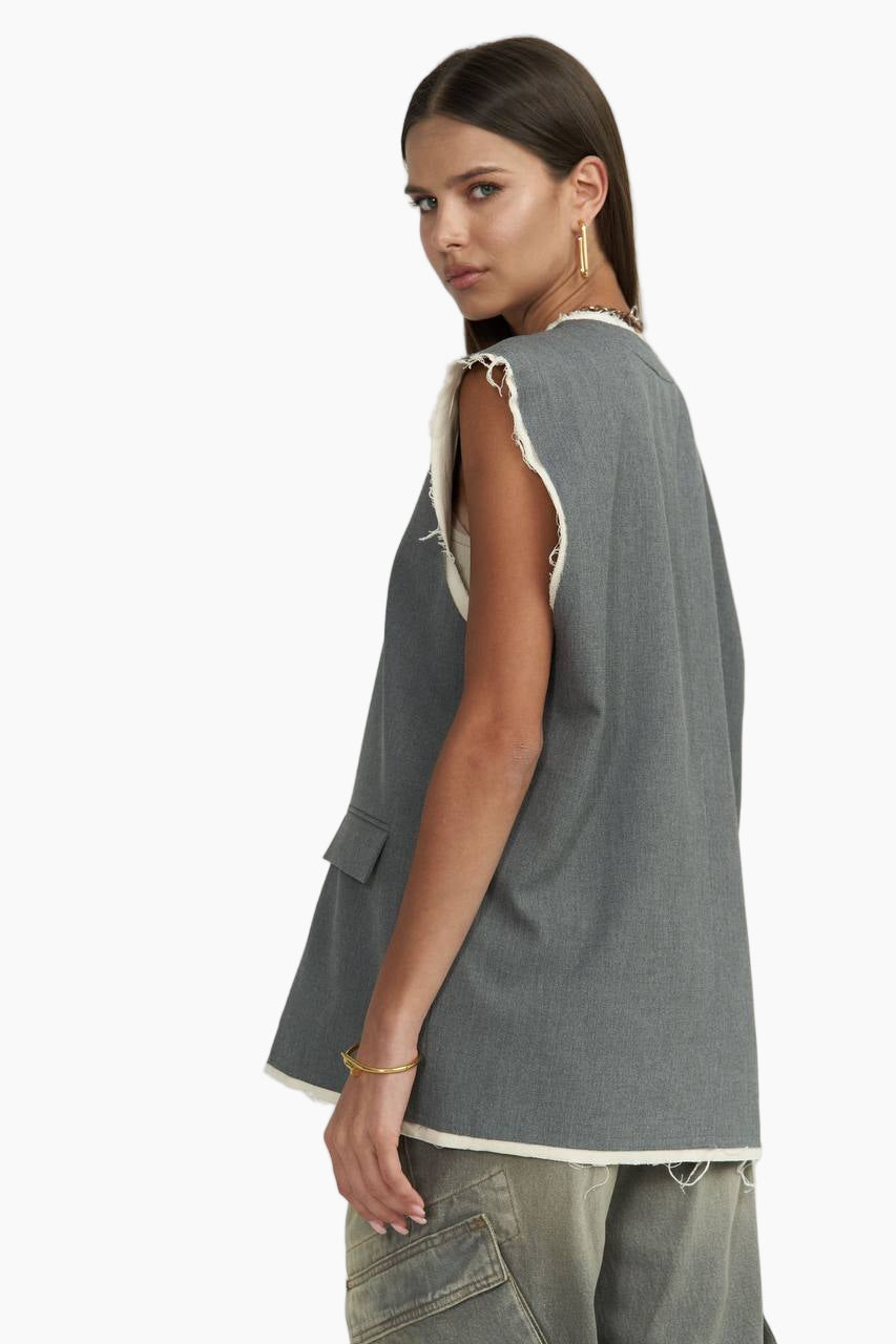Woman wearing a sleeveless gray top with a white trim on a white background