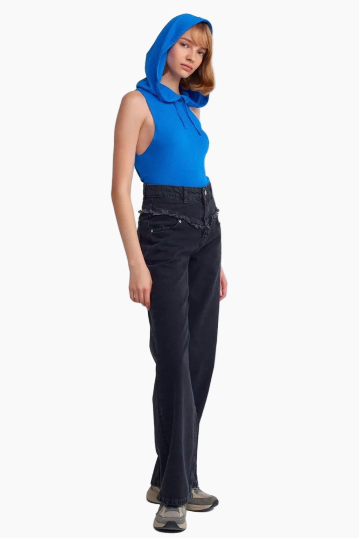 Person wearing a blue sleeveless top with a hood and black pants on a white background