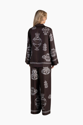 Woman wearing a brown outfit with decorative patterns on a white background