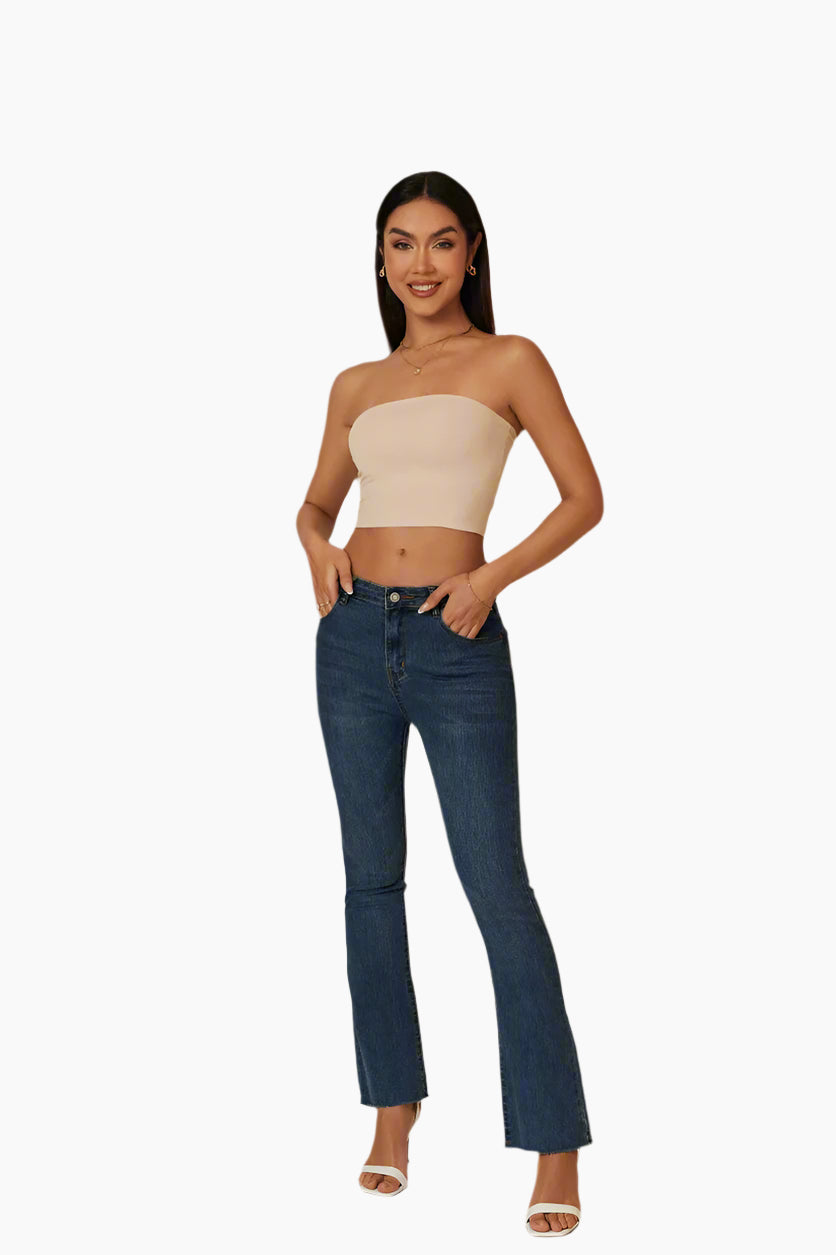 Woman wearing a beige strapless top and blue jeans