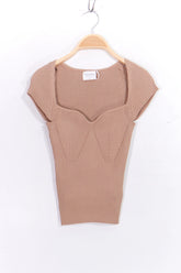 pink ribbed knit top on a wooden hanger 