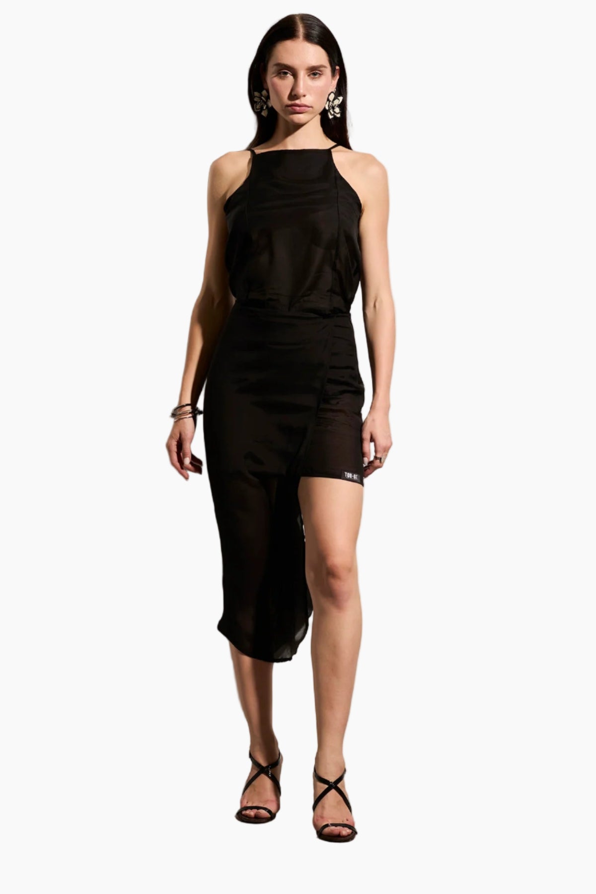 Woman wearing a black sleeveless top with Mid-length voile skirt in double layers with a playful twist.