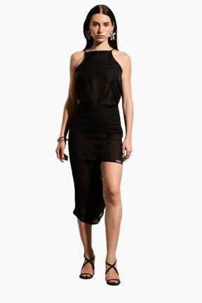 Woman wearing a black Voile top featuring an inner breast lining for coverage and adjustable back straps for a tailored fit.