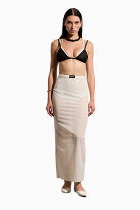 Woman wearing a black bra and beige skirt