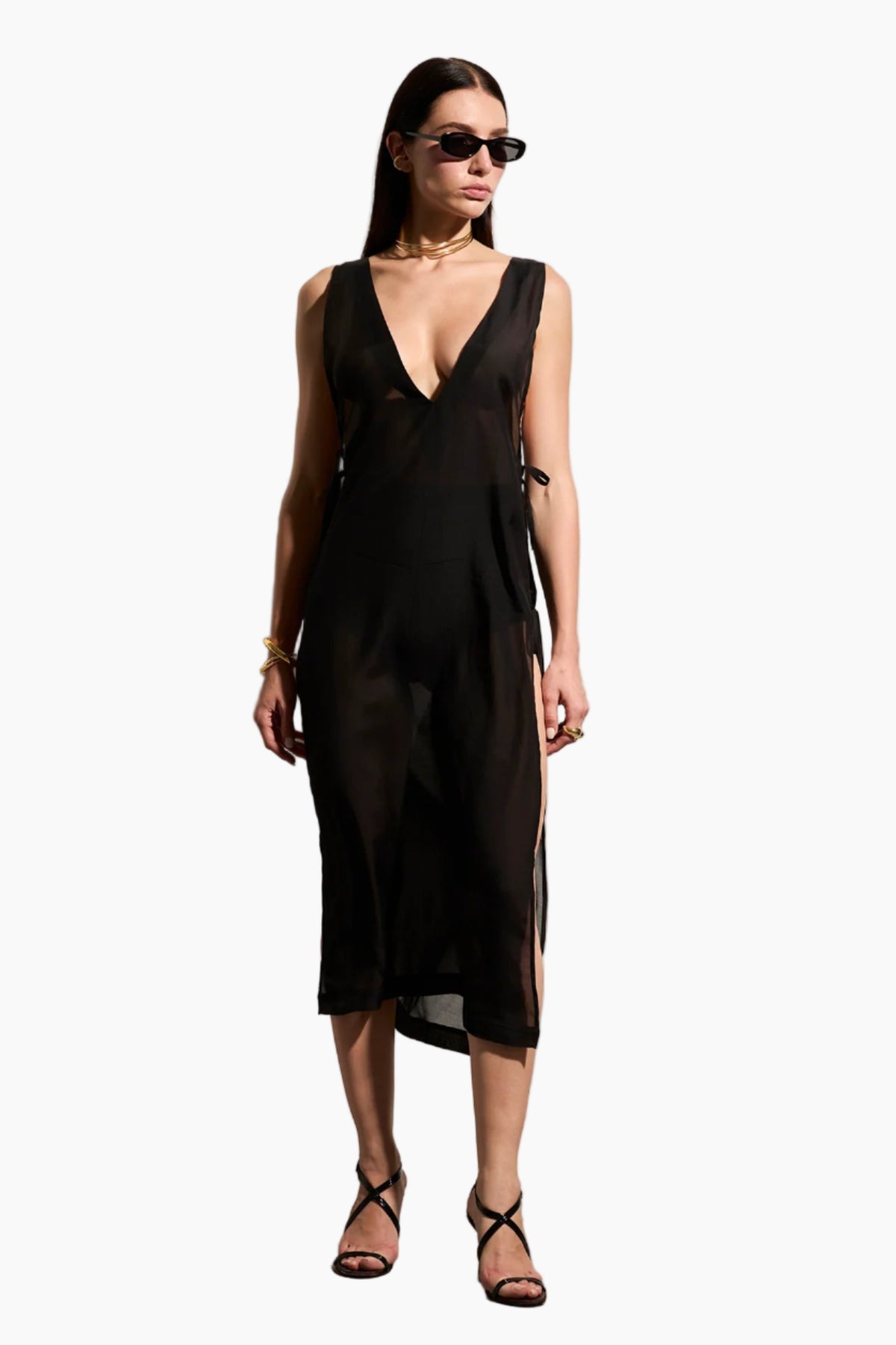 Woman wearing a black sleeveless Voile dress with side rope details.